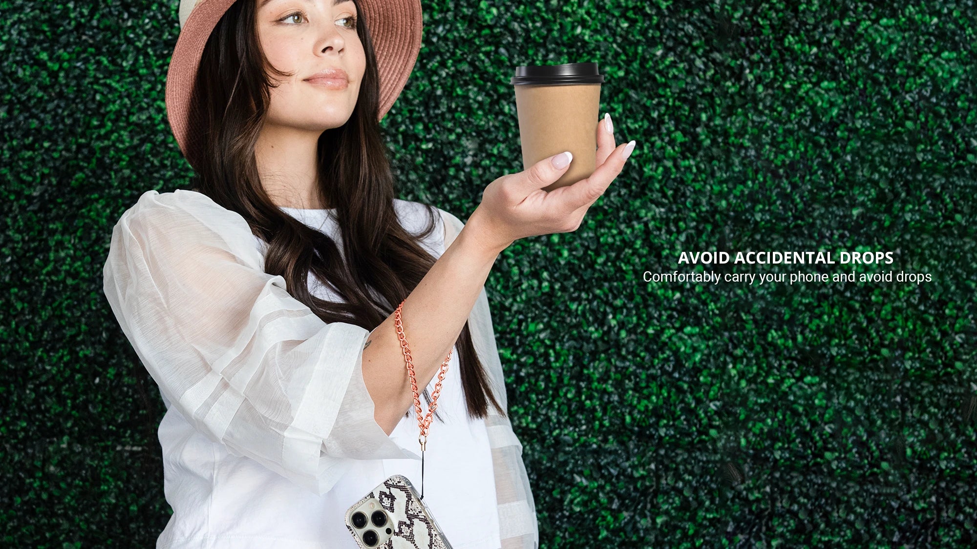 Holding a cup of coffee while showing rose gold phone wristlet charm
