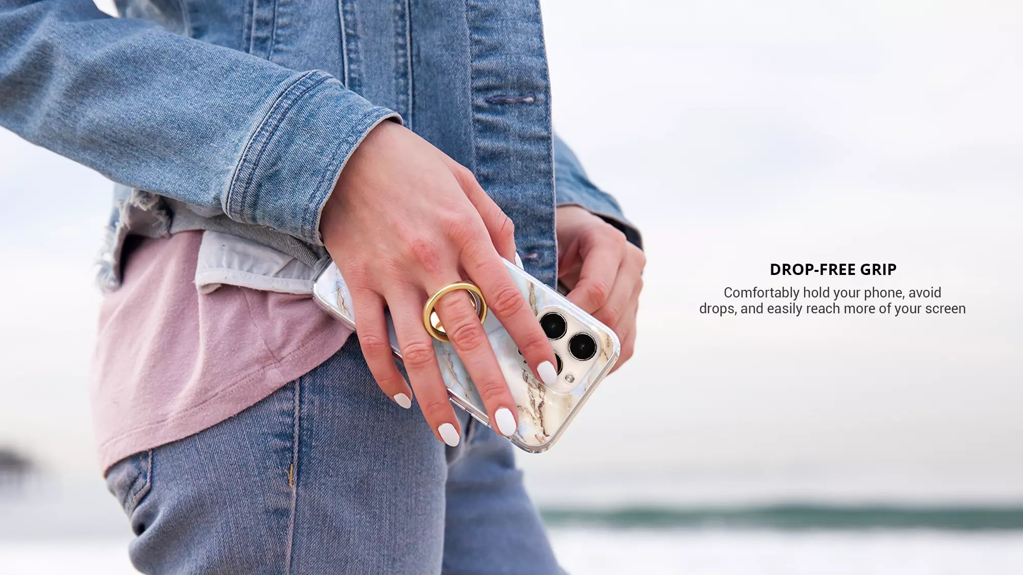 Using a gold phone ring on finger while wearing blue jeans jacket