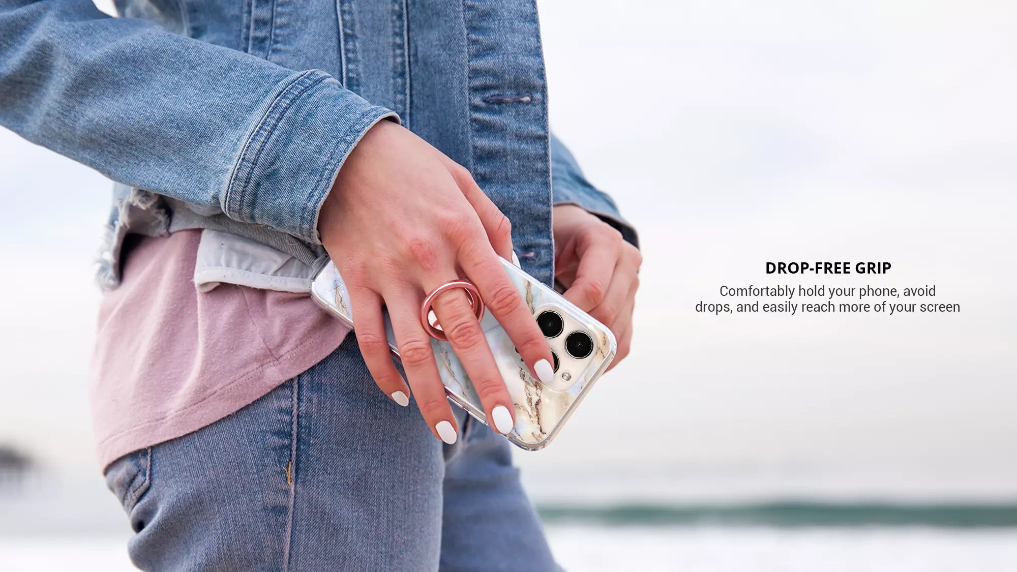 Using a Rose gold phone ring on finger while wearing blue jeans jacket
