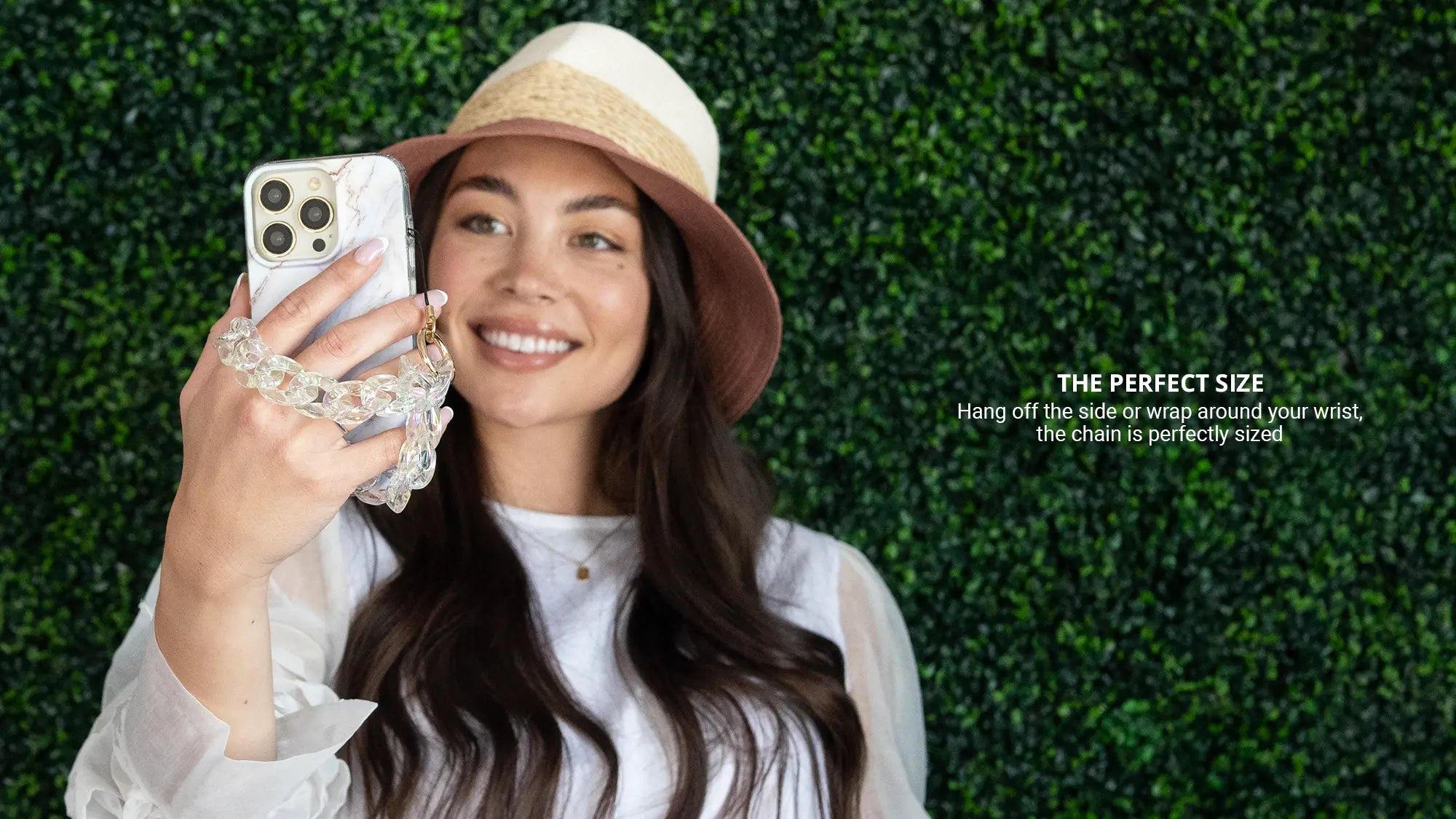 Clear holographic phone wristlet charm while wearing hat