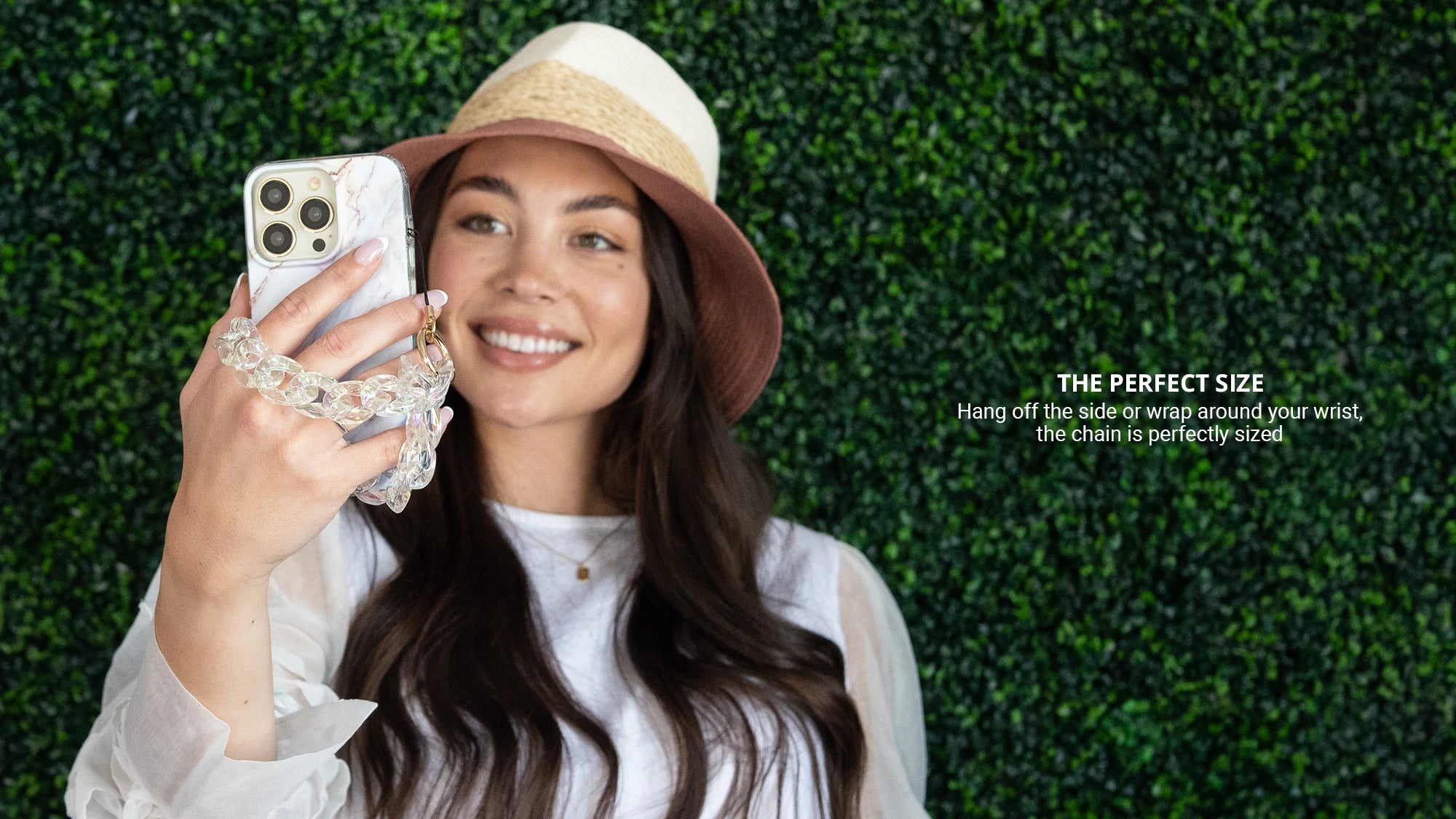 Taking a selfie with an iphone while holding clear holographic phone wristlet charm