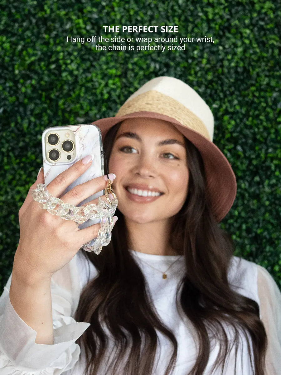 Clear holographic phone wristlet charm while wearing hat