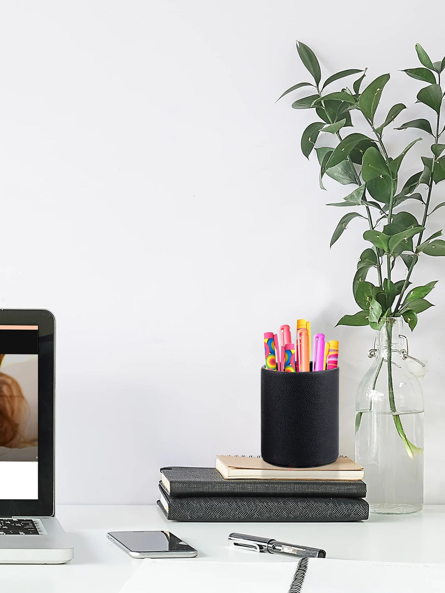 Faux leather pen holder with tablet and bottle with plants on the sides