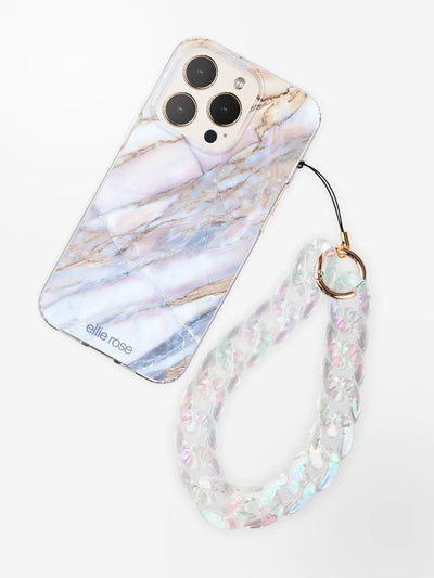 Clear holographic phone wristlet charm latched to Desert marble iPhone case