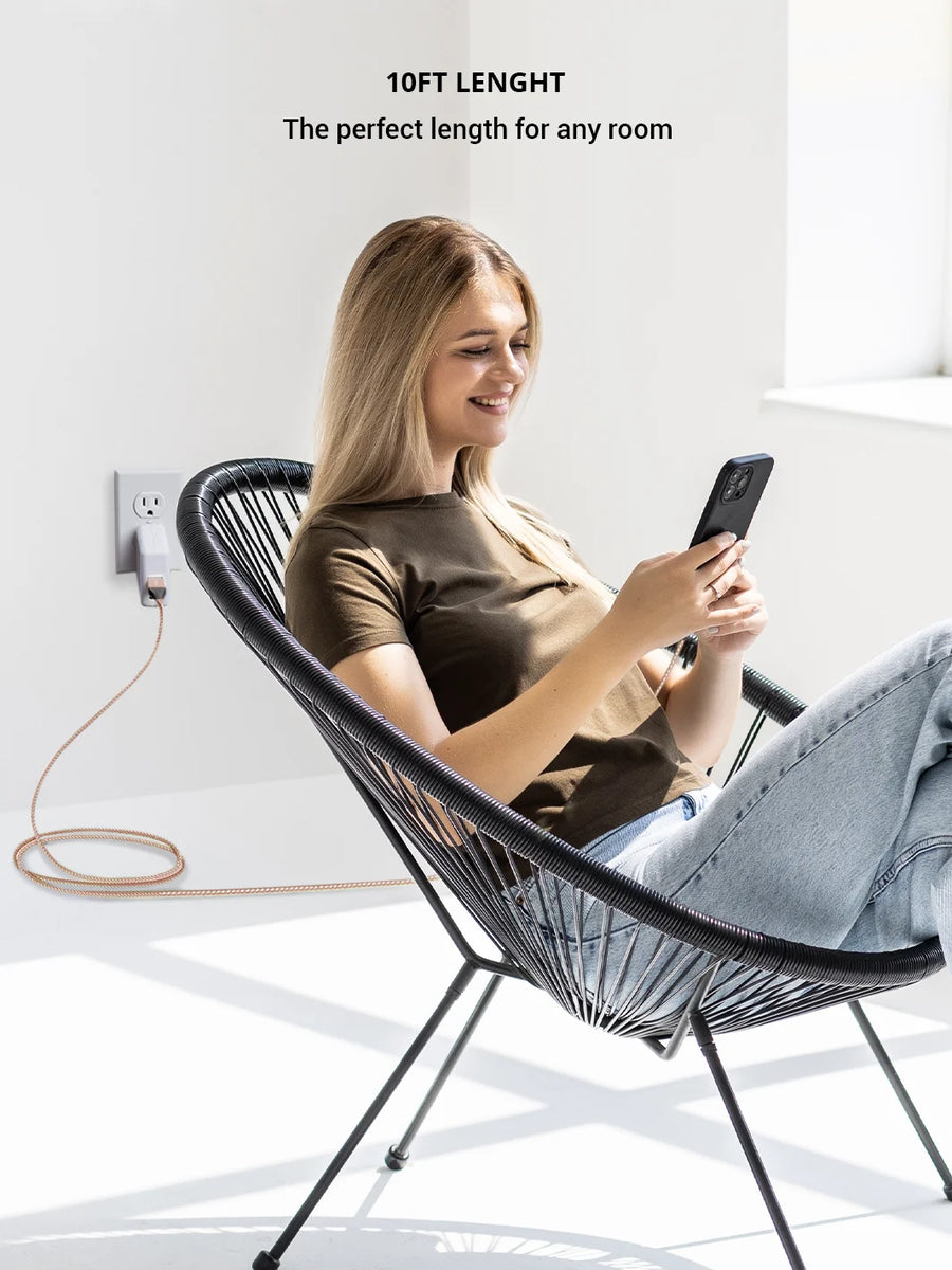 Charging an iphone using Rose gold 3 in 1 charger USB A sitting on black chair