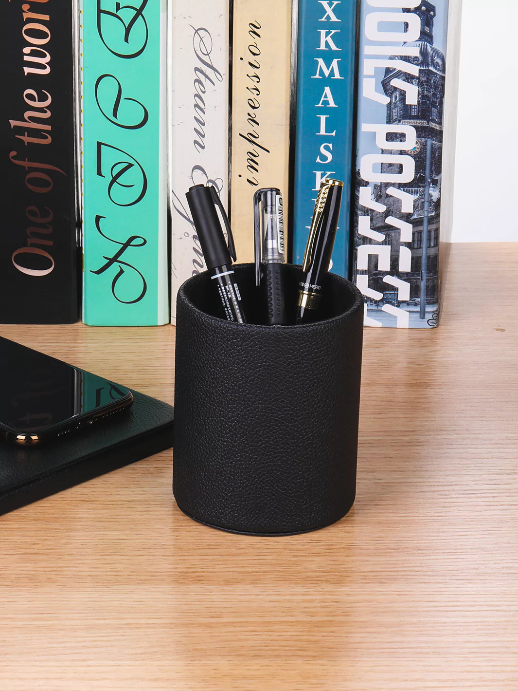 Black Faux leather pen cup with ballpens and books