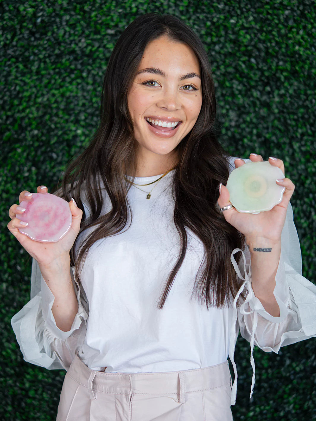 Holding 2 pcs Rose & Quartz Holographic Wireless Charger on green background