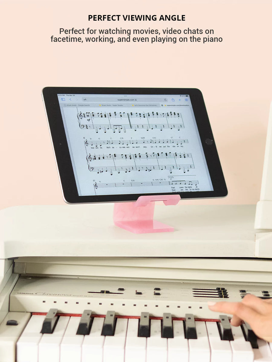 Rose quartz phone and tablet stand with an iPad and piano in the background