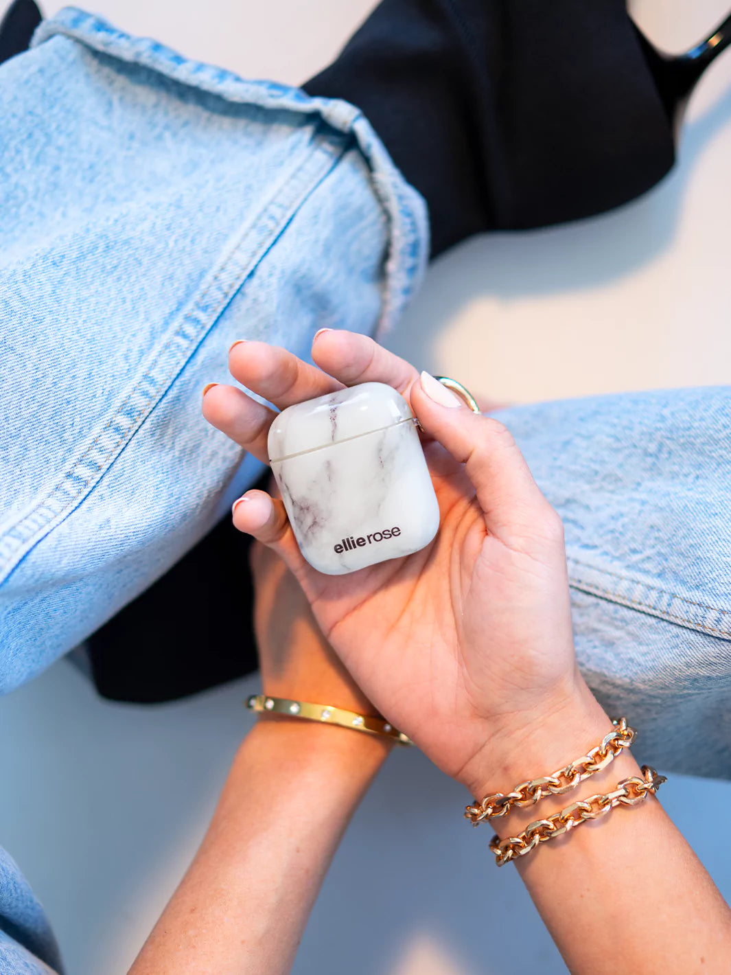 White Marble Airpods case on hand with gold bracelet