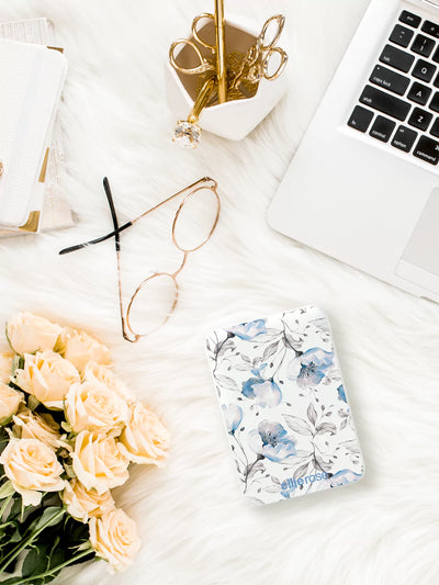 Blue floral powerbank on table together with laptop flowers and glasses