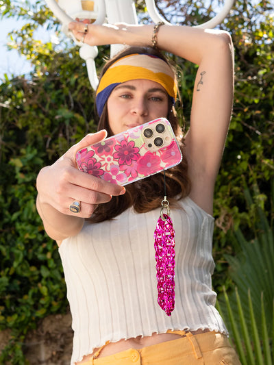 Took a selfie with pink floral iphone and pink holographic clear phone charm wristlet  wearing white top and yellow short