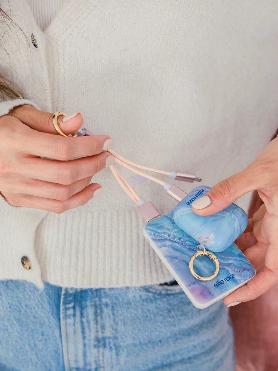 Holding 2 devices mystic journey airpods and powerbank with gold ring